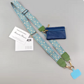 A shoulder strap bag set with a blue and white geometric patterned strap, olive green leather accents, a small blue zippered pouch, and printed cards on a light gray background.