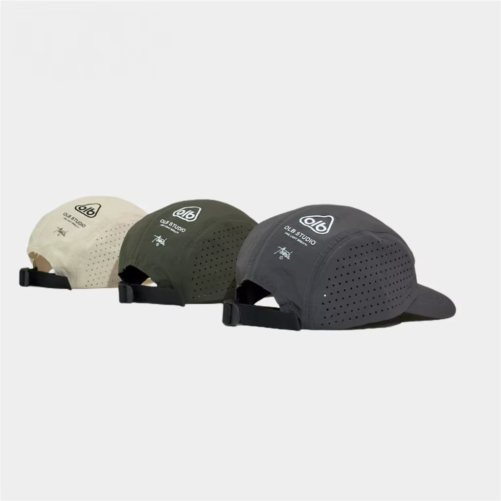 Three performance baseball caps shown from the back on a light gray background. The caps are in cream, olive green, and dark charcoal gray, each featuring a white printed logo and text on the back panel.
