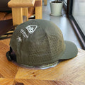 Green cap with a logo on a wooden surface