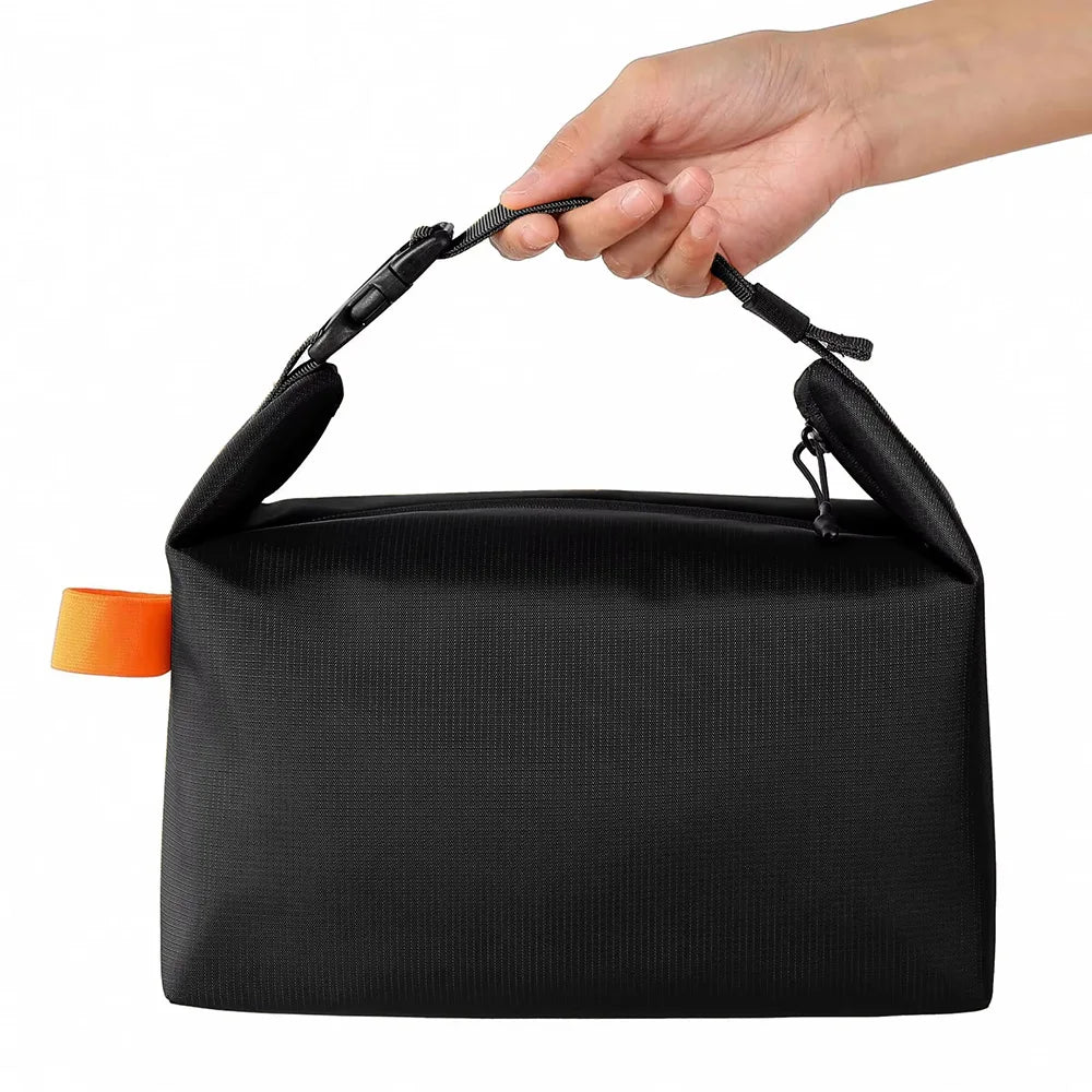 Black bag with an orange tag held by a hand on a white background