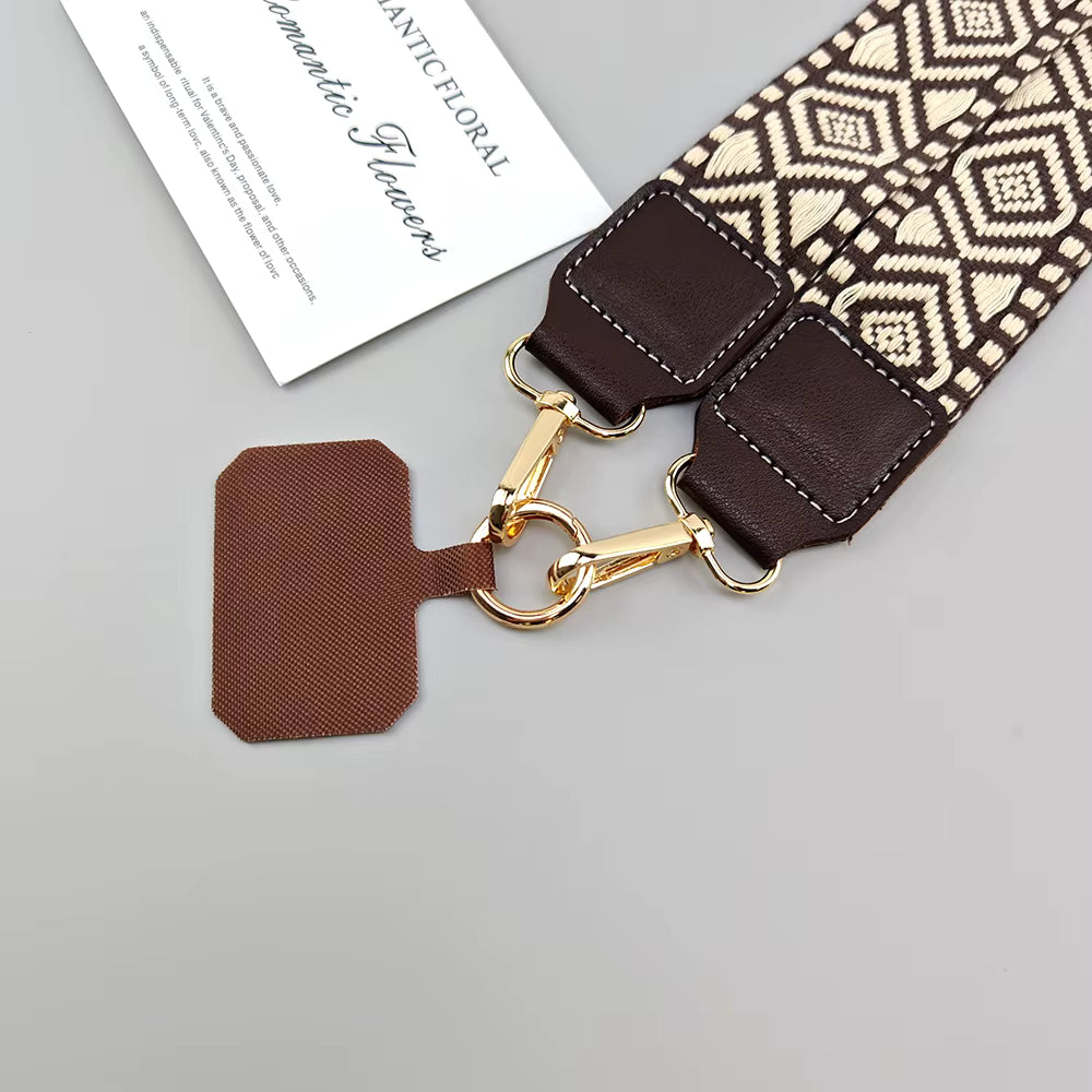 A close-up of a floral-patterned fabric flower stem with dark brown faux leather ends and gold-tone clasp hardware, shown on a light gray background with a small branded card.