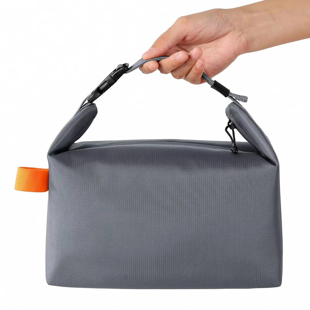 Gray bag with an orange tag held by a hand on a white background