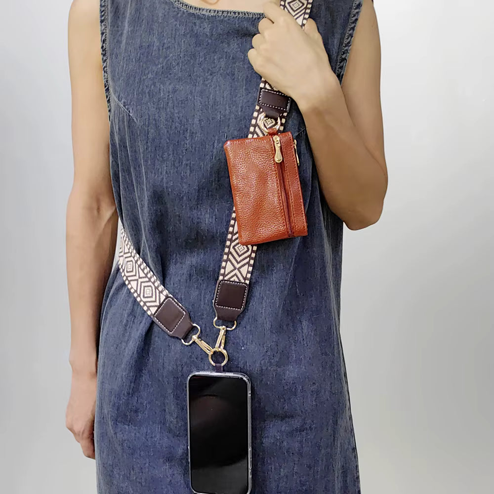 Person wearing a denim dress with a brown leather wallet and phone holder on a strap.
