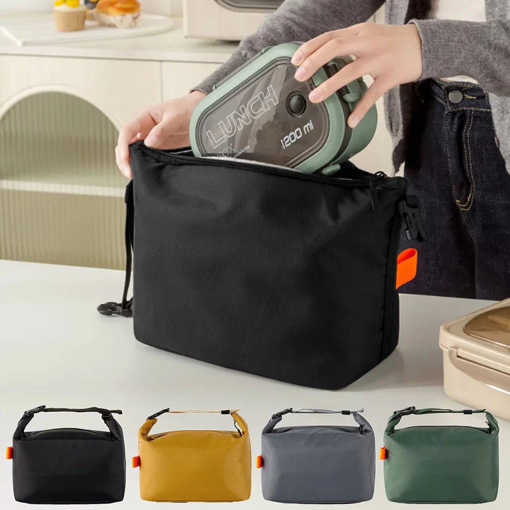 Person opening a black lunch bag with a thermos, surrounded by other lunch bags in different colors.